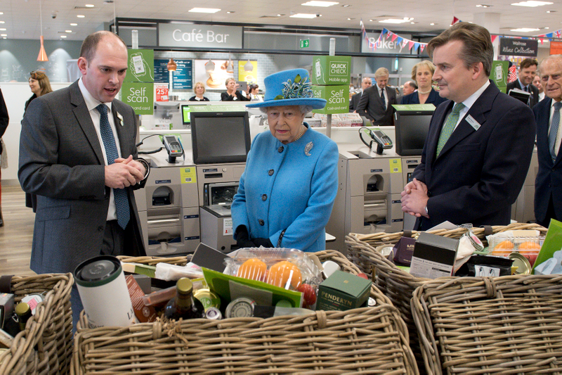 Britain’s Queen Elizabeth II looks at food hampers during a visit to a Waitrose supermarket in the town on October 27, 2016 in Poundbury, England. Photo via Getty Images.